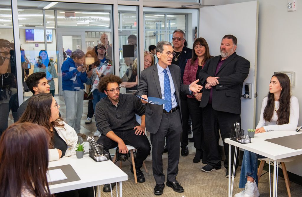 Bergen President Eric M. Friedman, Ph.D., speaks with student small business support specialists in their new office.